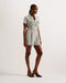 OSAMUD-Tailoring-We're making tailored style fun again with OSAMUD. This romper cuts a flattering silhouette with a wide leg design and wrap over front, complete with a built-in belt to cinch the waist. The boucle texture combined with vintage look buttons create a classic look, finished off with flap pockets on the chest. Go from office wear to evening drinks in this playful number. Tailored romper Boucle texture Wrap over design Notch lapel collar Flap chest pockets Belted waist Shiny button fastenings Ly