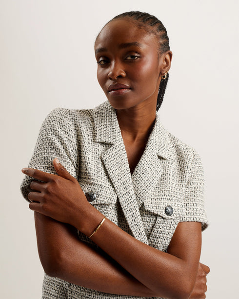 OSAMUD-Tailoring-We're making tailored style fun again with OSAMUD. This romper cuts a flattering silhouette with a wide leg design and wrap over front, complete with a built-in belt to cinch the waist. The boucle texture combined with vintage look buttons create a classic look, finished off with flap pockets on the chest. Go from office wear to evening drinks in this playful number. Tailored romper Boucle texture Wrap over design Notch lapel collar Flap chest pockets Belted waist Shiny button fastenings Ly