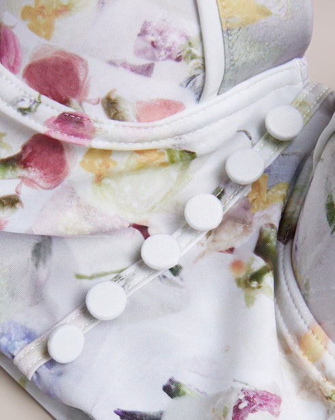 ULANIA-Swimwear-The ULANIA bikini top makes for sweet swimwear with a pressed floral print and faux button detailing down its longline design. Underwire and padding on the bust create a flattering and supportive fit, with removable straps for versatile style. It fastens at the back with a branded hook, finished with a playful cut-out detail. Longline bikini top Pressed floral print Faux button detail Back cut out Padded cups with underwire Removable and adjustable straps Hook fastening Lydia is 5'10" / 1.77