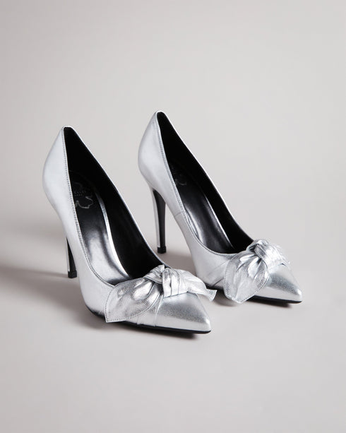 SILVEYY-Shoes-Get ready to bow down to your shoe collection with your latest addition, SILVEYY. The silver lining to any outfit, the classic court shoe can be worn to a wide range of events, while the bold metallic and elegant bow design allows these to take centre-stage of any outfit. 10cm heel Bow design Court shoe style Ted Baker-branded- Ted Baker Romania