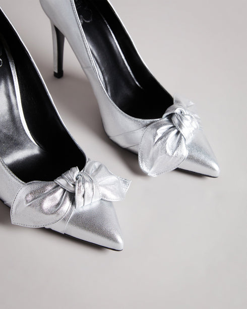 SILVEYY-Shoes-Get ready to bow down to your shoe collection with your latest addition, SILVEYY. The silver lining to any outfit, the classic court shoe can be worn to a wide range of events, while the bold metallic and elegant bow design allows these to take centre-stage of any outfit. 10cm heel Bow design Court shoe style Ted Baker-branded- Ted Baker Romania