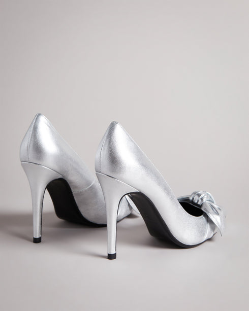 SILVEYY-Shoes-Get ready to bow down to your shoe collection with your latest addition, SILVEYY. The silver lining to any outfit, the classic court shoe can be worn to a wide range of events, while the bold metallic and elegant bow design allows these to take centre-stage of any outfit. 10cm heel Bow design Court shoe style Ted Baker-branded- Ted Baker Romania