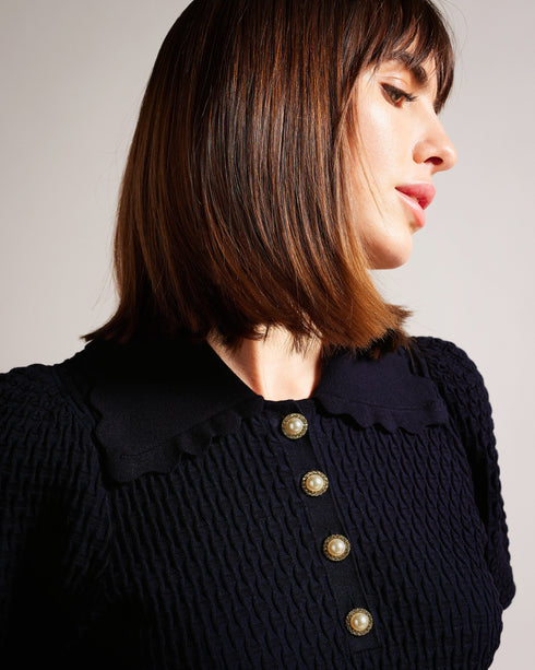 REANNIA-Knitwear-Short puff sleeves and a texture knit make REANNIA go the extra mile, while the faux pearl buttons give it a little extra flair. Stretch fabric will take you through the day with ease. Polo top Short puff sleeves Faux pearl buttons Textured knit Scalloped collar Stretch fabric Julia is 5'10" / 1.78m and wears Dark Blue in a Ted size 1- Ted Baker Romania