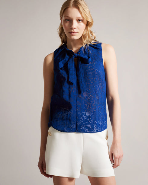 ADELAAI-Tops-Let your wardrobe bloom with the ADELAAI top, boasting a sleek floral devoré fabric with a playful neck tie and versatile sleeveless silhouette. With its seamless transition from day to night, this top is a wardrobe essential. Sleeveless top Devoré floral design Neck tie Gathered neckline Jara is 5'10.5" / 1.79cm and wears Bright Blue in a Ted size 1- Ted Baker Romania