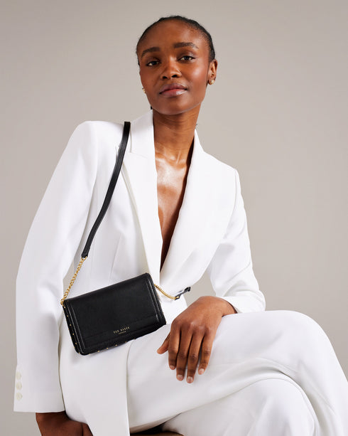 KAHNISA-goods-Carry around your card collection with KAHNISA. This leather purse has all of the card slots and zip compartments you'll ever need, with a fold over cover to keep them safe. The adjustable chain & leather shoulder strap allows for stylish carrying, finished with a studded trim for maximum style. Leather purse Studded trim Zip coin compartment Multiple card slots Foldover cover with magnetic fastening Adjustable chain and leather shoulder strap External zip pocket Dimensions: 10.5cm x 2.5cm- Te